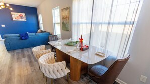 En matplats med ett träbord, vita stoppade stolar och en blå soffa i bakgrunden.