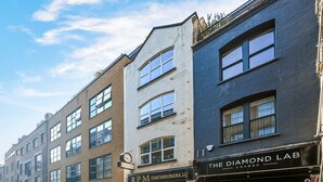 Katunäkymä, jossa näkyy rakennuksia, mukaan lukien panttilaitos ja myymälä nimeltä ”The Diamond Lab”.