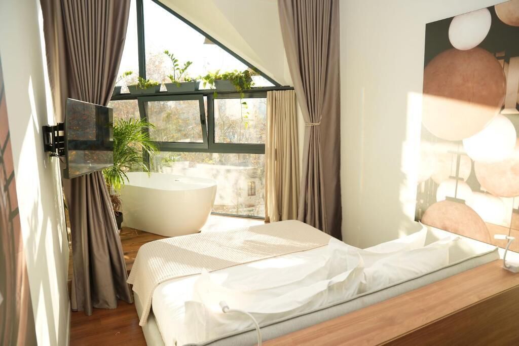 Une chambre moderne avec une grande fenêtre, une baignoire et un lit.