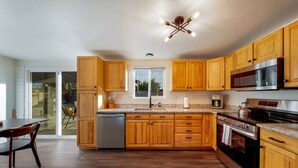 A kitchen with wooden cabinets, stainless steel appliances, and a dishwasher. - Pool / 4 BR 2 BA / Davis-Monthan AFB / Renovated (Tucson)