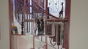 A wooden-framed view into a staircase with a metal railing and a giraffe sculpture. - KILIMANJARO PAZURI VILLAS(KPV) (Moshi)