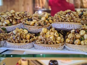 Une vitrine remplie de pâtisseries décorées de noix, dans une boulangerie.