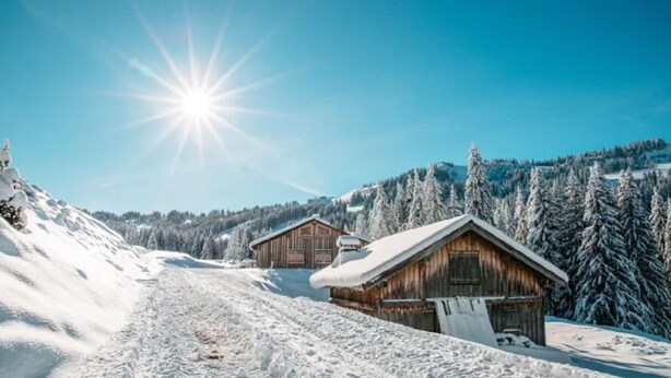 A snow-covered mountain landscape with wooden cabins.