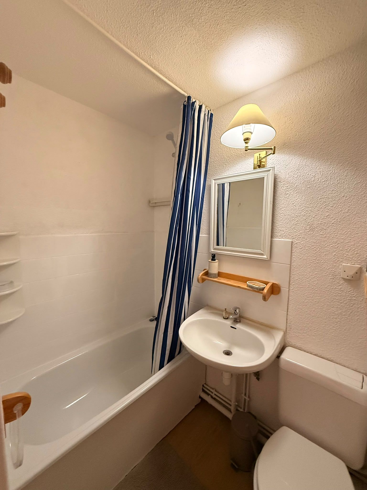 A compact bathroom with a bathtub, a sink, and a toilet.