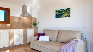 A cozy living room with a beige sofa, a small table, and a painting on the wall. - Ayurvila Wellness Retreat (Manacor)
