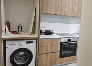 A compact kitchen with a washing machine, a Bosch dishwasher, and a Bosch oven. - 125 EGM 1 - Stay Engomi Gem 1 (Egkomi)