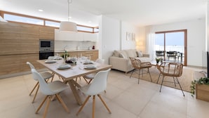 A modern kitchen with a dining area, a sofa, and a TV. - Villa Los Altos Alene 10B by Escape Home (Playa Blanca)