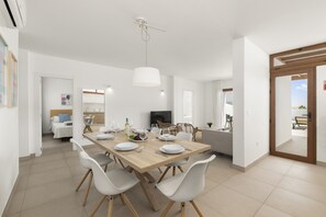 Ein stilvoller Essbereich mit Holztisch, weißen Stühlen und einer Pendelleuchte.