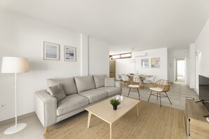 Ein modernes Wohnzimmer mit Sofa, Couchtisch und Essbereich.