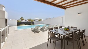A rooftop terrace with a pool, dining area, and lounge chairs. - Villa Los Altos Yaiza 9A by Escape Home (Playa Blanca)