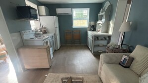 A compact living space with a kitchenette, a sofa, and a coffee table.