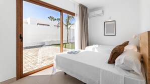 A bedroom with a bed, a window, and a view of the outside. - Villa Los Altos Deva 12A by Escape Home (Playa Blanca)