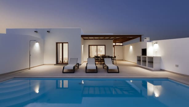 A modern pool area with lounge chairs and a dining area. - Villa Los Altos Deva 12A by Escape Home (Playa Blanca)