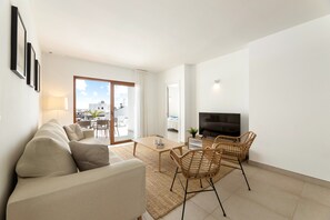 A modern living room with a sofa, chairs, a coffee table, and a TV. - Villa Los Altos Tabaiba 7A by Escape Home (Playa Blanca)
