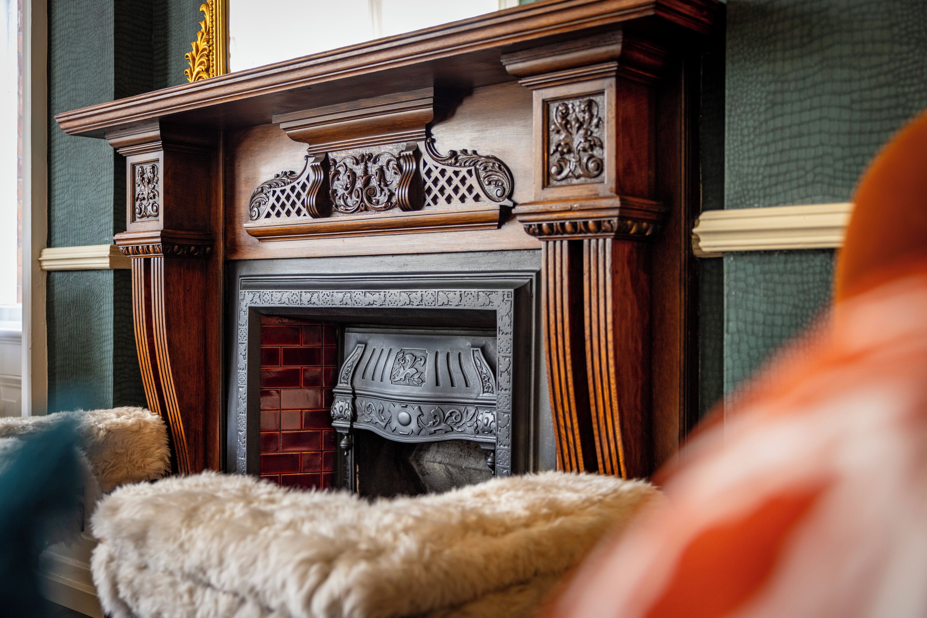 A fireplace with intricate woodwork and a brick surround.