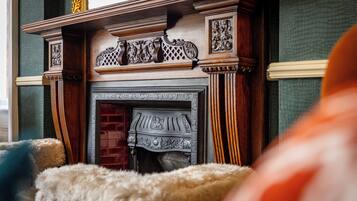 A fireplace with intricate woodwork and a brick surround.