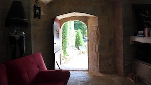 A stone archway leading to an outdoor area with greenery and a patio. - Le Grand Gîte Renaissance au Château (12 pers.) - Lot (Saint-Chamarand)