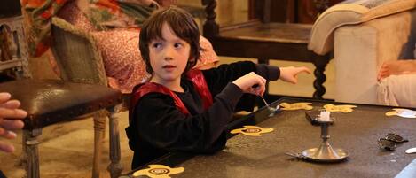 A child playing with a toy at a table with a decorative pattern.