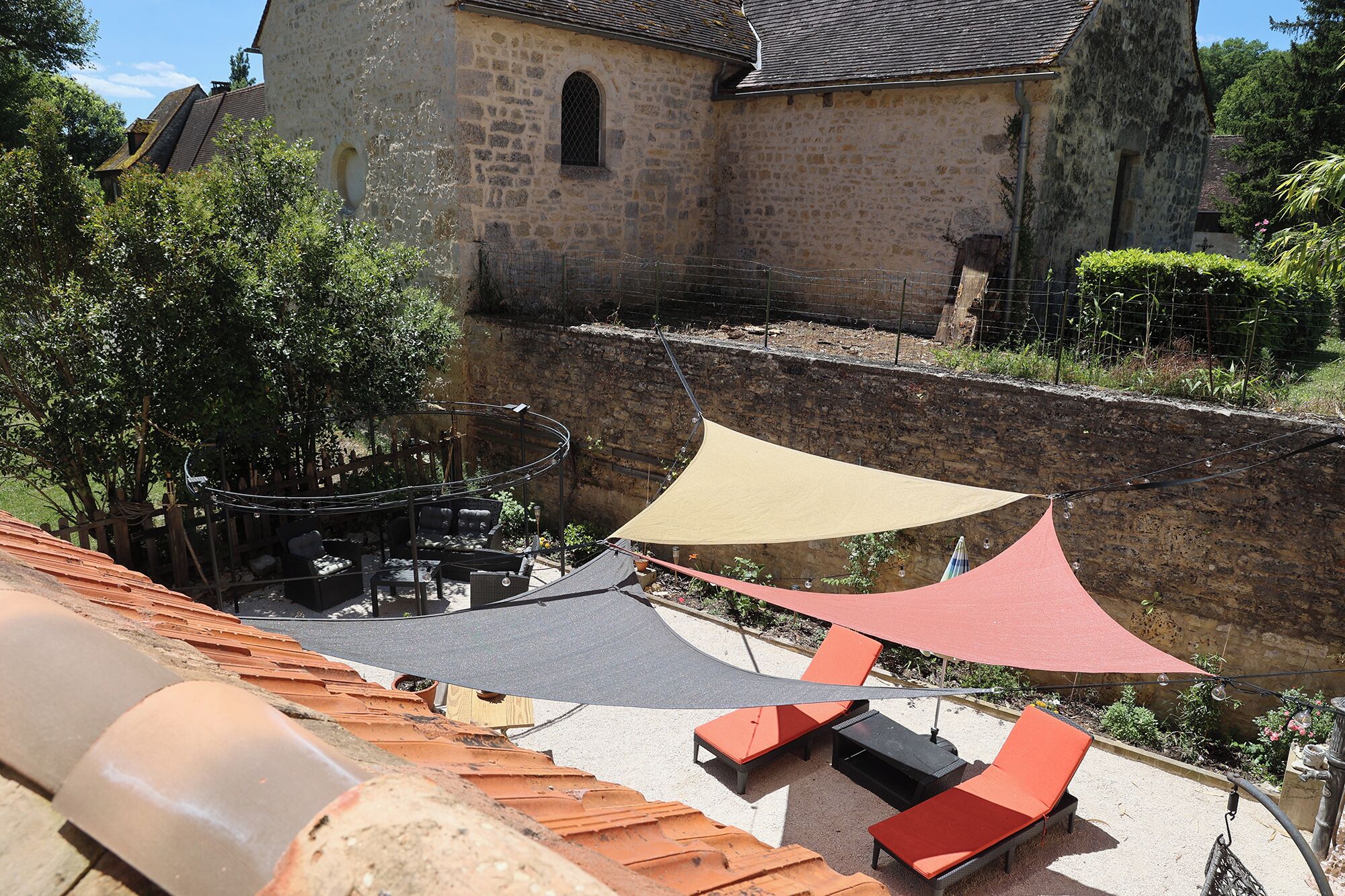 A terrace with outdoor seating and a stone wall.