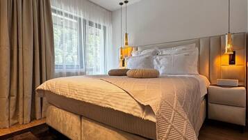 Un dormitorio moderno con una cama grande, una mesita de noche y una lámpara colgante.