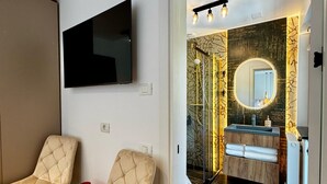 Ein modernes Badezimmer mit einem großen Spiegel, einem Waschtisch und einer Duschkabine.