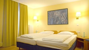 A hotel room with two beds, yellow curtains, a painting on the wall, and two bedside lamps. - Hotel Villa Kisseleff (Bad Homburg v.d. Hoehe)