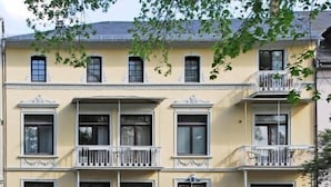 A multi-story building with balconies, a gated entrance, and a car parked in front. - Hotel Villa Kisseleff (Bad Homburg v.d. Hoehe)