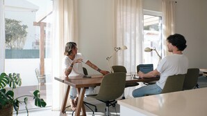 Une pièce moderne avec une grande fenêtre, une table en bois et deux chaises.