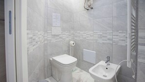 A modern bathroom with a toilet, bidet, and sink.