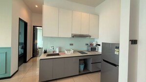 Una cocina moderna con armarios grises, un microondas y un lavabo.