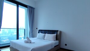 Una habitación de hotel moderna con una cama grande, un ventilador de techo y vistas de la ciudad a través de la ventana.