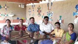 A group of people seated around a table with a glass top in a room with a tiled floor and a wooden ceiling. - Rann Roshni Homestay – Family Friendly Stay in Kutch 6 (Bhirandiara)