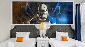 A hotel room with two beds, a nightstand, a lamp, and a large space-themed painting on the wall. - 25% Off 5BR Resort Pool/Lazy river/Slides/Gym (Davenport)