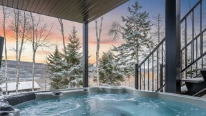A hot tub with a view of snow-covered trees and a sunset. - Spa, Views & Nature | Panoraama Finlandais (Saint-Côme)