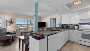 A modern kitchen with white cabinets, a granite countertop, and a built-in oven.