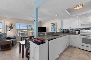 A modern kitchen with white cabinets, a granite countertop, and a built-in oven. - LIV Sea Cottage, Boat dock, Pool, Golf! (Port Isabel)