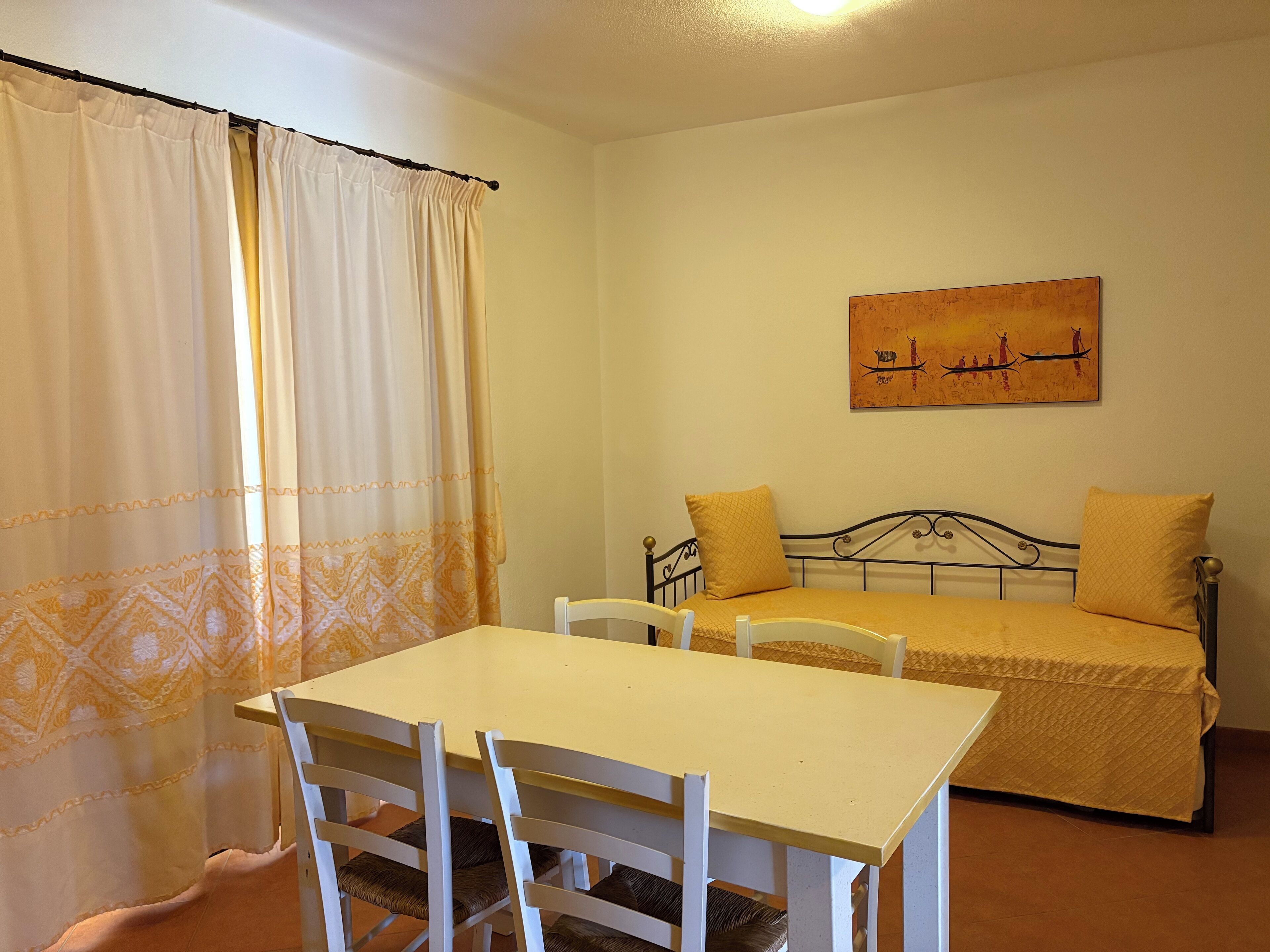 Una stanza con un letto, un tavolo e delle sedie.