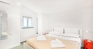 A hotel room with a bed, a nightstand, a mirror, and a window. - Welcome to Country View, your next ideal destination for a romantic and relaxing getaway! Located in the picturesque village of Groppo, just minutes from Riomaggiore, perfect for 2 people, couples or friends looking for a quiet retreat. You can enjoy the (Riomaggiore)