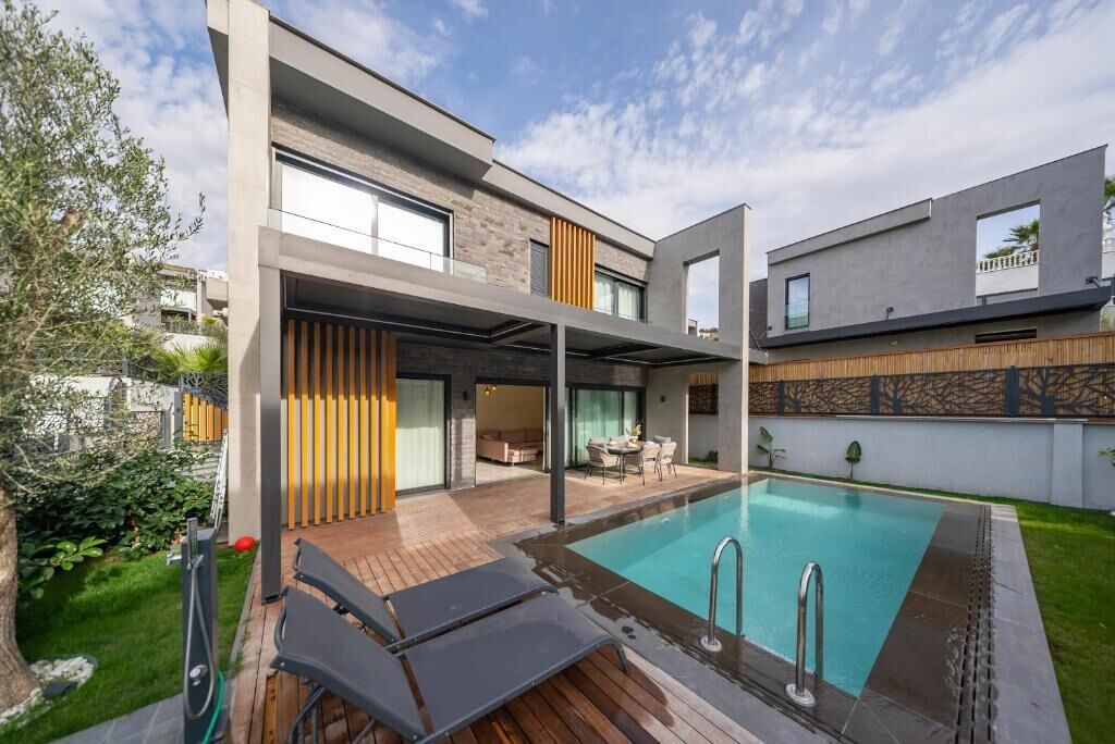 A modern house with a swimming pool, a covered patio, and a garden.