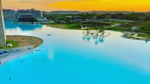 Una piscina grande con vistas a un hotel y el paisaje circundante.