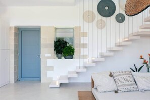 A modern interior with a staircase, a door, a window with plants, and a sofa with cushions. - Brand New Villa, Private Heated Pool, Quiet,Luxury (Daratsos)