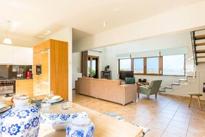 A modern living space with a kitchen, dining area, and a sofa set. - Villa Staride, heated pool, sea view, family, cozy (Paidochori)