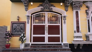 A grand entrance with a double door, ornate columns, and a sign reading "Grand Palace". - SK Grand Palace (Puducherry)