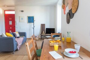 Ein Wohnzimmer mit Sofa, Esstisch und Frühstücksecke.
