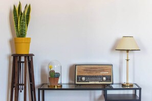 Ein Tisch mit einem Blumentopf, einem Radio und einer Lampe.