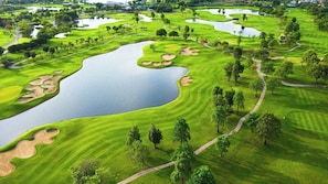 Ein Golfplatz mit mehreren Teichen, Sandbunkern und Wegen.