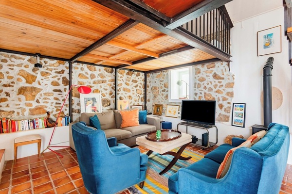 Rustic living room with comfortable sofas and a wood-burning stove.
TV and Books for your entertainment.