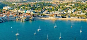 An aerial view of a coastal town with a marina, buildings, and a beach. - Casalinho de Bicesse (Alcabideche)