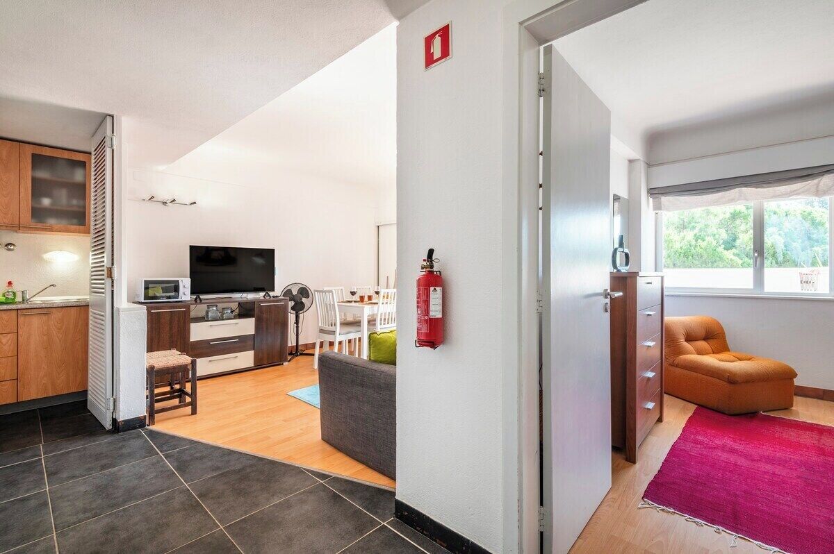 Un intérieur moderne comprenant une cuisine, un coin repas et un salon avec un canapé et un téléviseur.