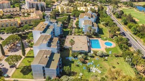 Zona residencial con edificios modernos, piscina y campo de golf.